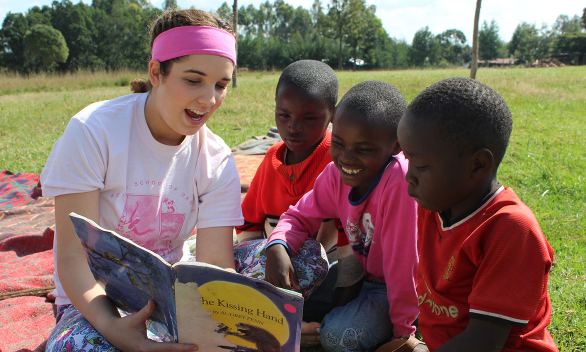 volunteer reading to children at Rapha Community Center